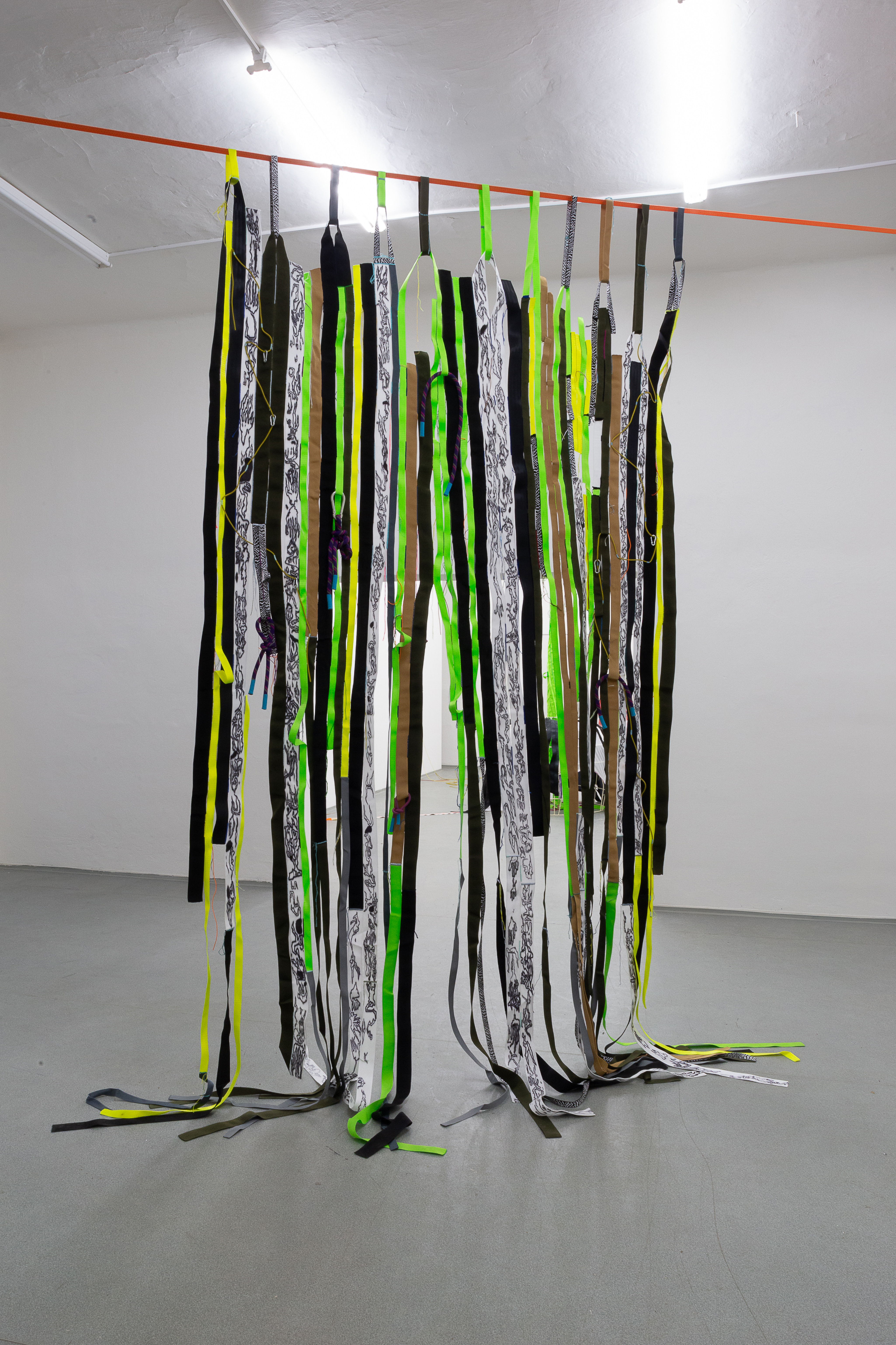 Photo of an art object called Graft by Klára Čermáková (Galerie FaVu, Brno, Czechia, 2018) [Front view]. A front view of the Graft, the kind of artificial tissue stitched mainly from seat belts and technical straps, hangs in the middle of the room and thus hides the rest of the exhibition.