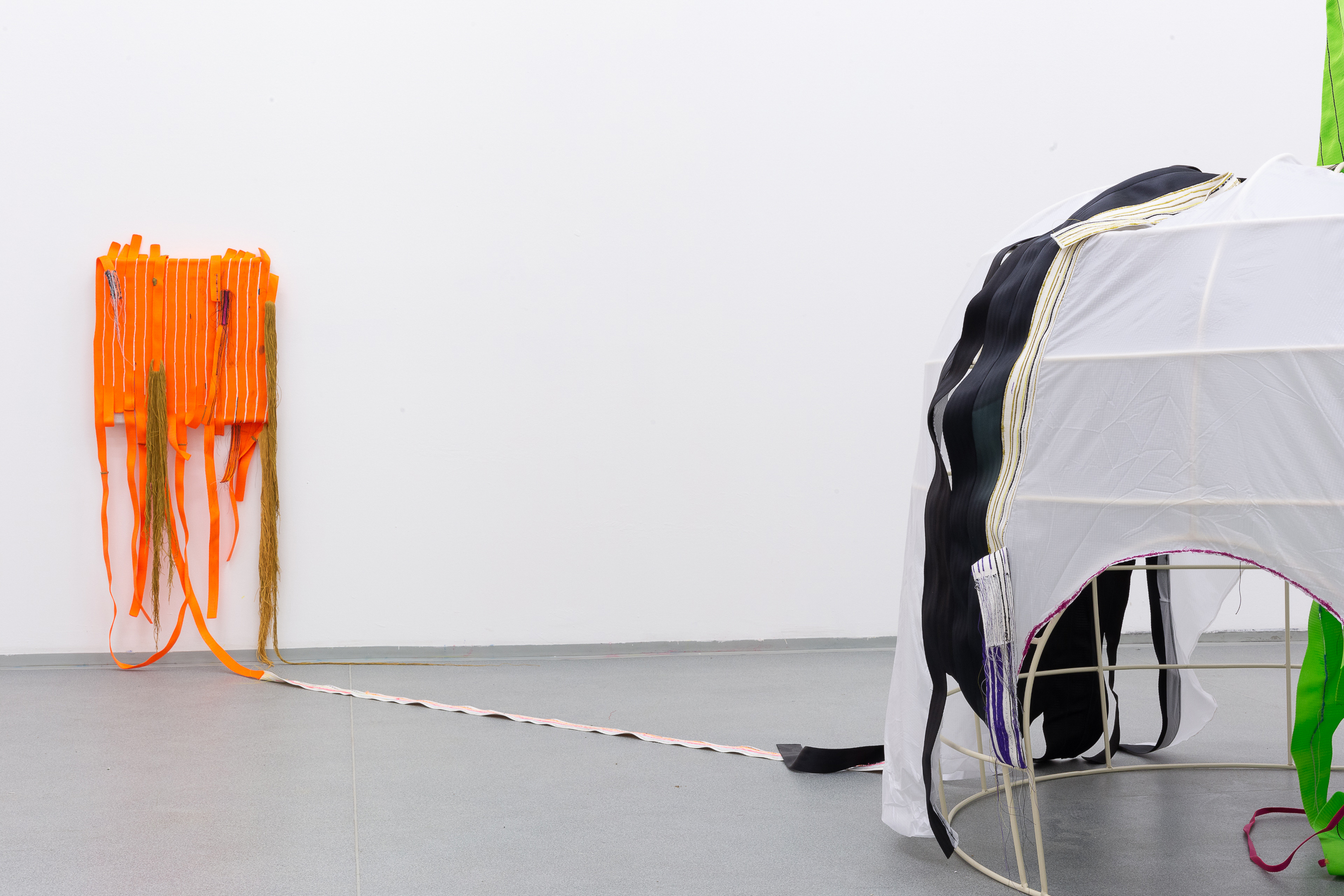 Photo of an art installation called Hands (and Other Products of Labor) 2.0 by Klára Čermáková (Mikulov Art Symposium, Mikulov, Czechia, 2021) [Detail no. 3]. A detailed view of the central object of the exhibition (the tent) and one of the stitched paintings connected to it.